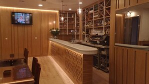 A restaurant with a wooden interior, a bar area, and a television screen mounted on the wall. - Abadi (Córdoba)