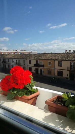 A balcony with potted plants and a view of buildings. - Abadi (Córdoba)
