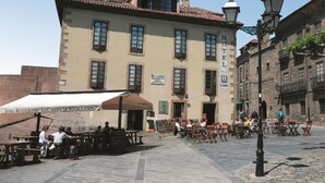 A hotel with outdoor seating and a sign indicating it is a restaurant. - Hotel La Casona de Jovellanos (Gijon)
