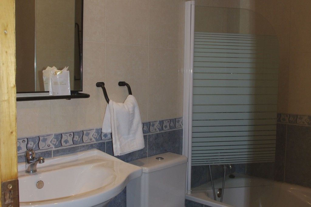 A bathroom with a sink, toilet, and shower.