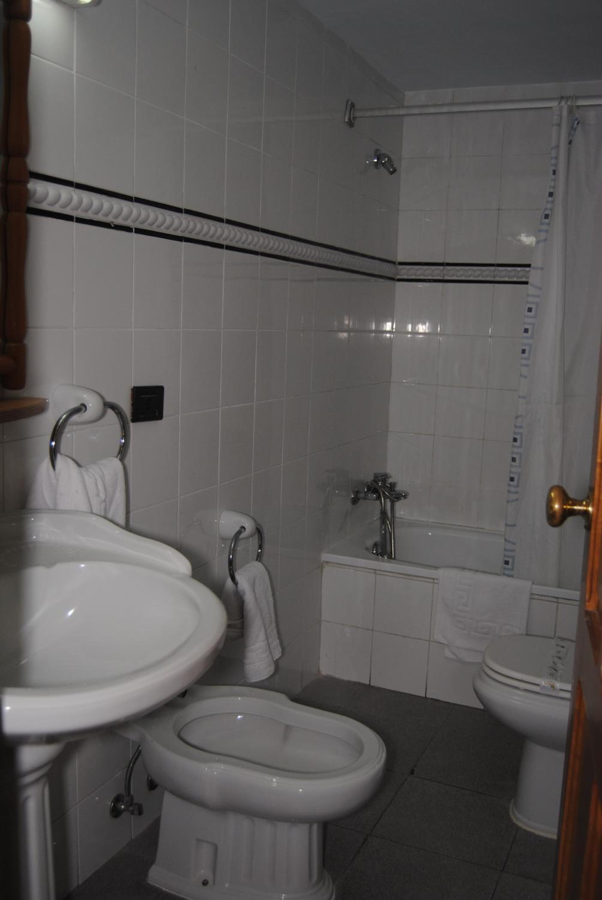 Um banheiro com vaso sanitário, bidê e pia.