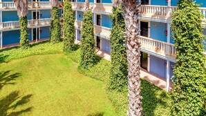 A hotel with multiple floors, each with balconies and a well-maintained lawn. - Vibra Blanc Palace Aparthotel (Ciutadella de Menorca)