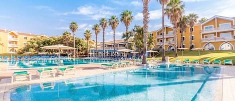 Una piscina al aire libre de temporada, sombrillas