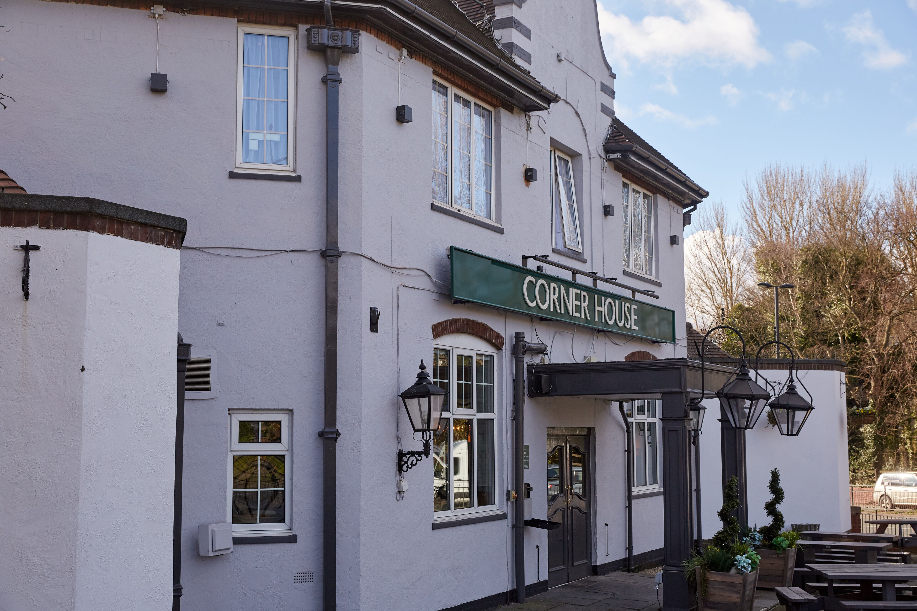 A corner building with a sign reading "Corner House".