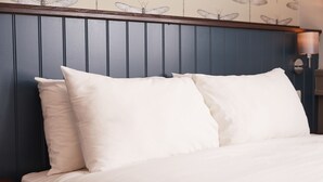 A neatly made bed with white linens and pillows, a wooden headboard, and a wall with butterfly wallpaper. - Corner House Hotel by Greene King Inns (Newcastle-upon-Tyne)