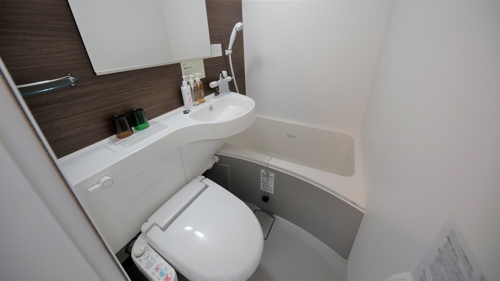 Un bany compacte amb un vàter blanc, un lavabo i una banyera.