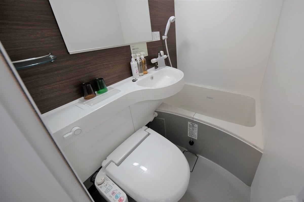A compact bathroom with a white toilet, a sink, and a bathtub.