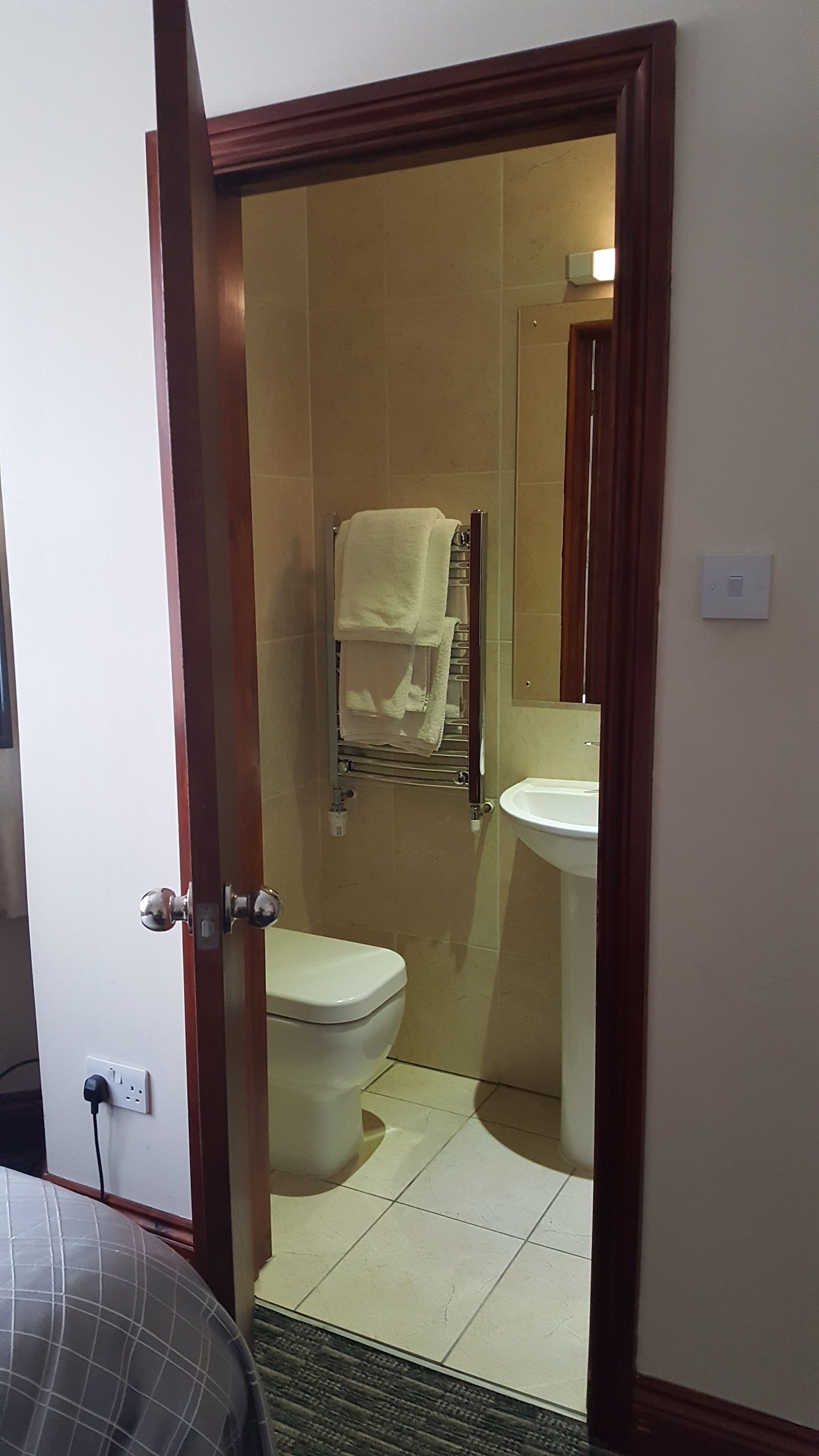 Ein Badezimmer mit Toilette, Waschbecken und Handtuchhalter.