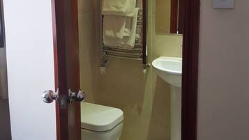 Ein Badezimmer mit Toilette, Waschbecken und Handtuchhalter.