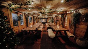 Una habitación acogedora con paredes de madera, una chimenea y un árbol de Navidad.