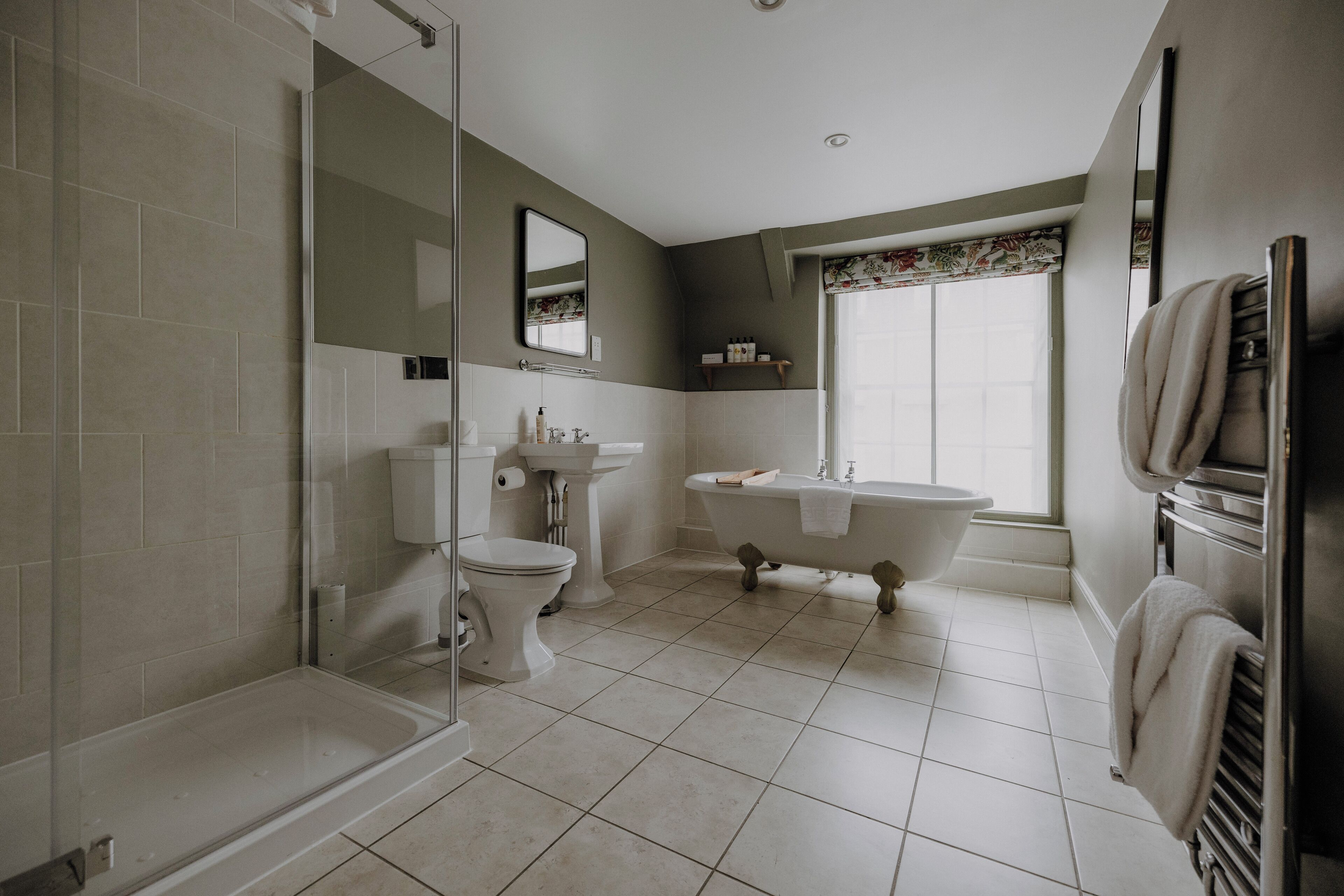Un baño moderno con cabina de ducha de vidrio, inodoro, lavabo y bañera independiente.