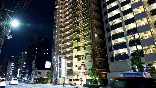 A multi-story hotel with illuminated balconies and a prominent sign.