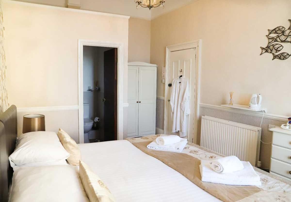 Une chambre d’hôtel comprenant un lit, une armoire, un radiateur et un porte-serviettes.
