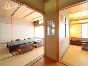 A traditional Japanese room with tatami flooring, a low table, and sliding doors. - Hotel Kawakyu (Shirahama)