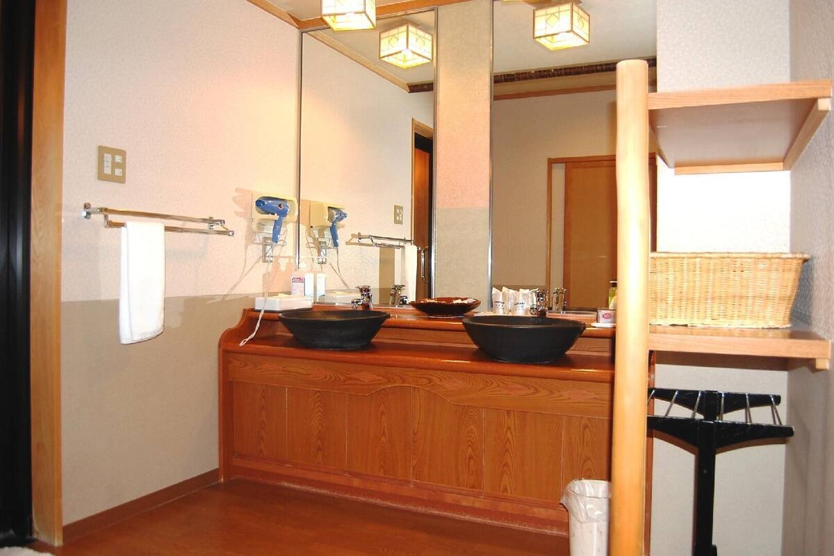 A bathroom with two sinks, a mirror, and a wooden vanity.