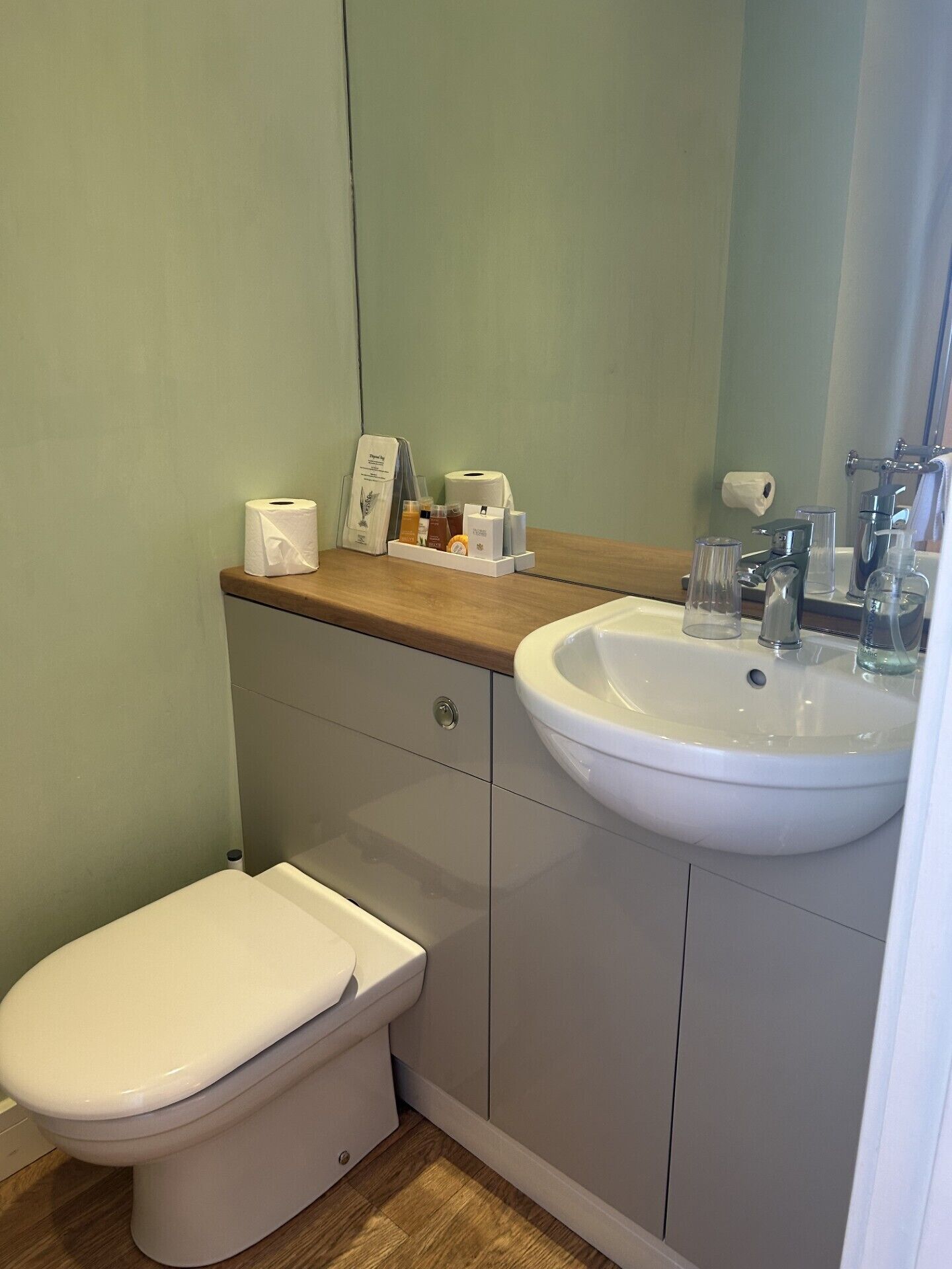 Ein Badezimmer mit Toilette, Waschbecken und Spiegel.