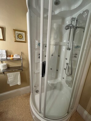 A glass-enclosed shower with a handheld showerhead and a handheld faucet. - Moresby Hall (Whitehaven)