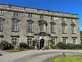 Un edificio de piedra grande con varias ventanas y una entrada central.