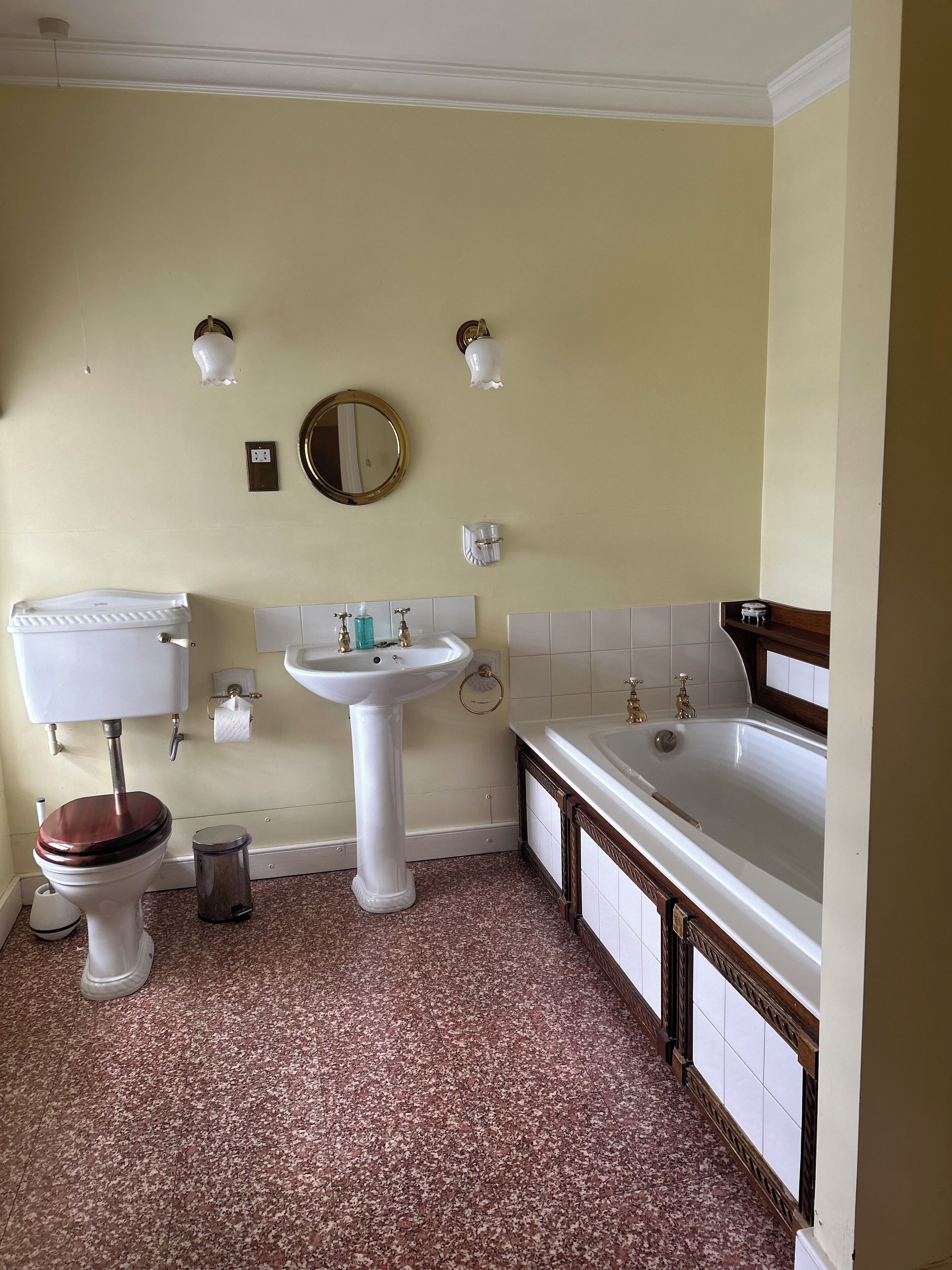 Une salle de bain avec des toilettes, un lavabo et une baignoire.