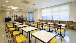 A classroom with rows of desks and chairs, a clock on the wall, and a window with blinds. - Hotel Econo Tsu Station (Tsu)