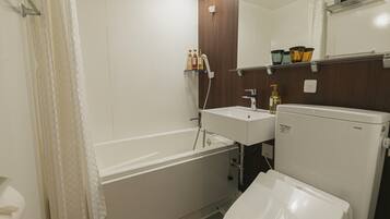 Un baño moderno con bañera, lavamanos e inodoro.