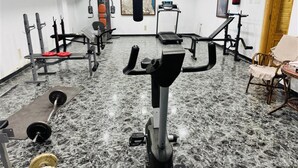 A gym with various exercise equipment, a punching bag, and a fire extinguisher on the wall. - Albohera Playa hotel by Belvilla Resorts (San Javier)