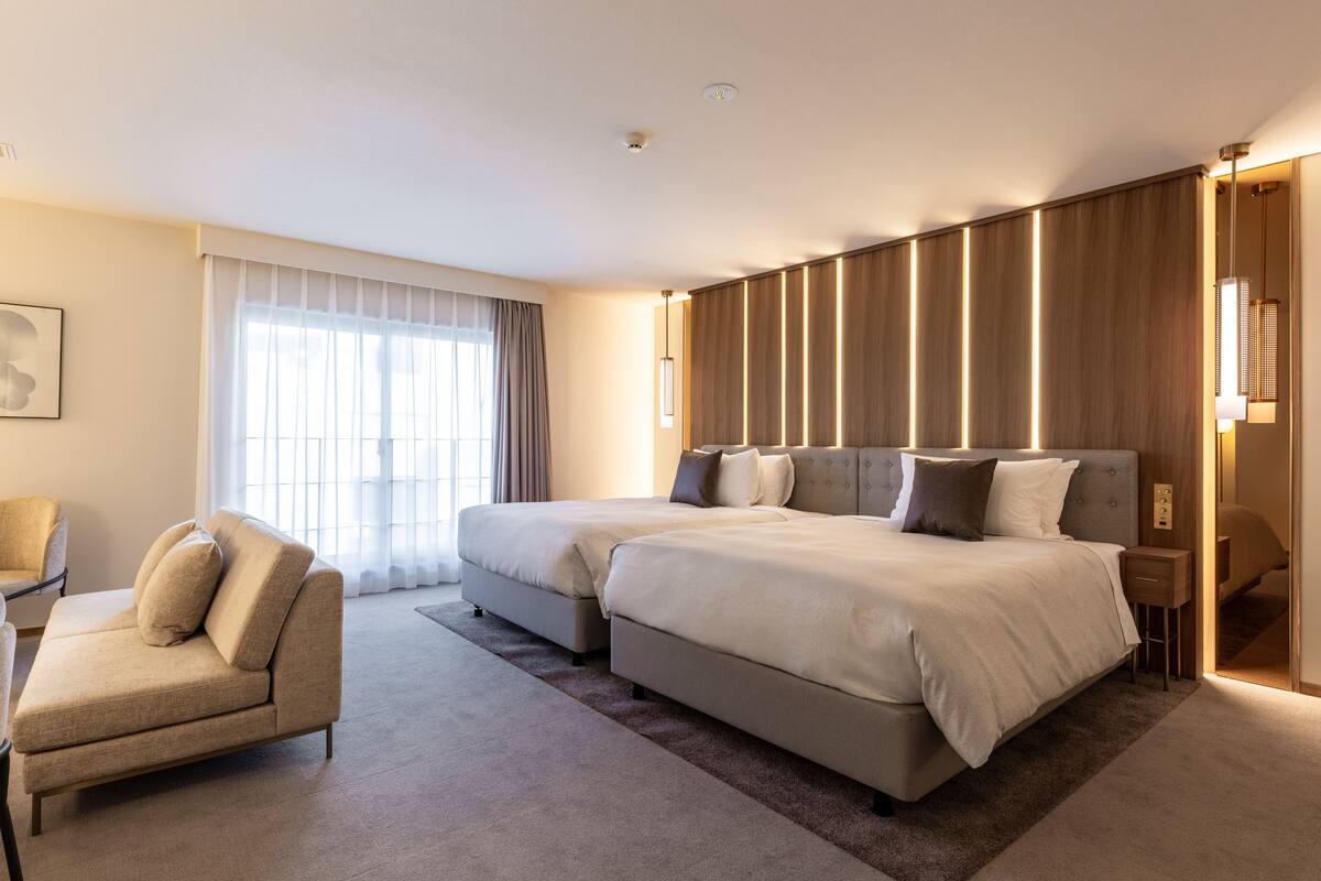 Una habitación de hotel moderna con una cama grande, un sofá y un escritorio.