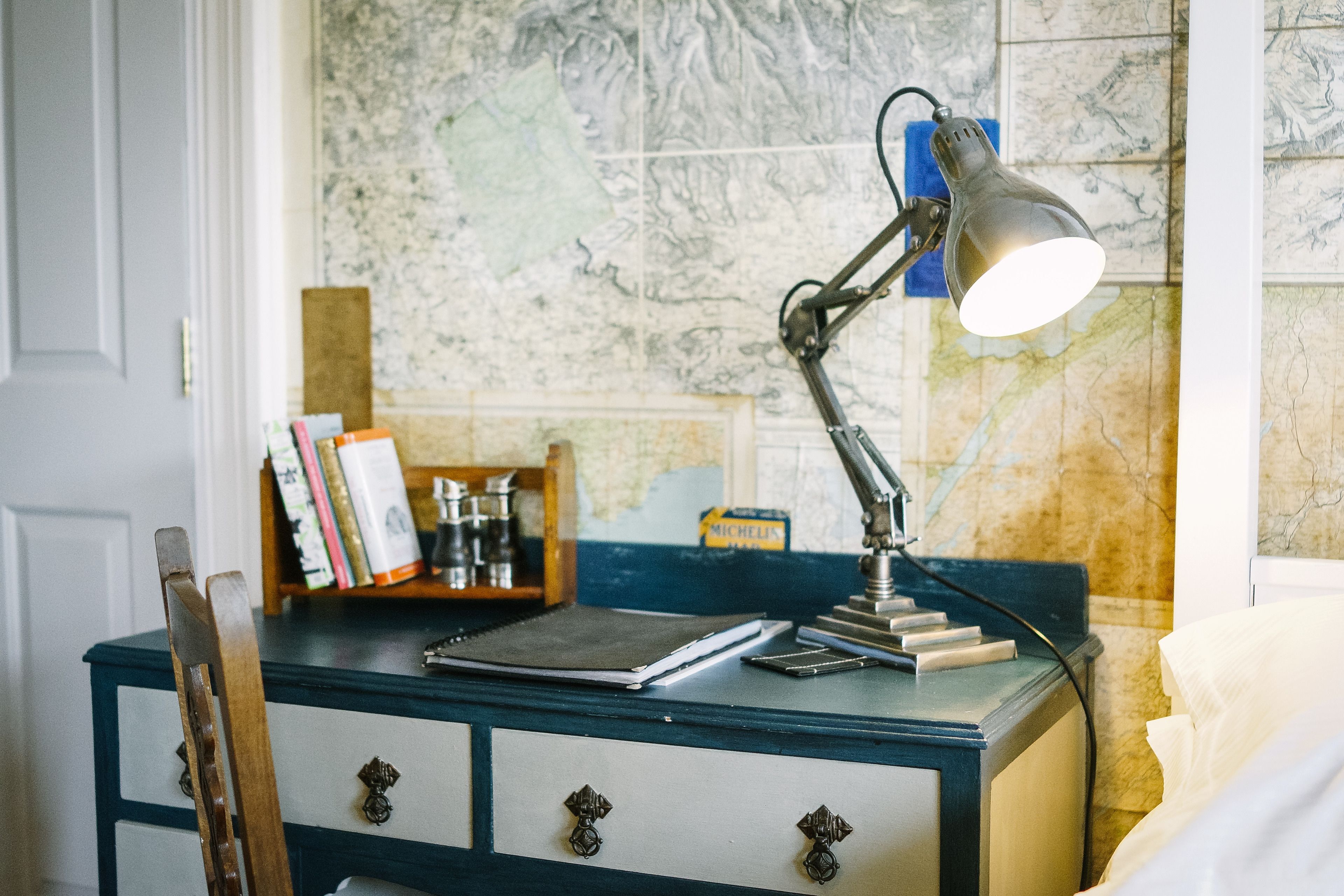 Un bureau avec une carte, une lampe et un carnet.