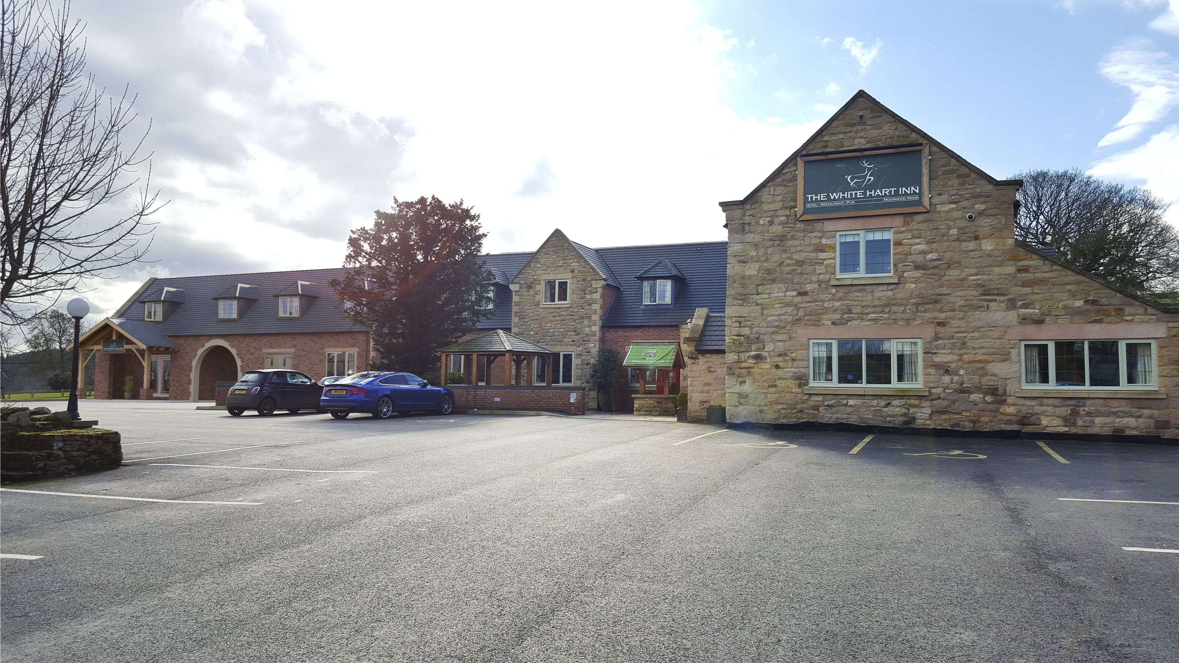 A stone building with a sign reading "The White Hart Inn."