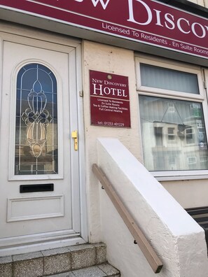 A hotel sign with a stained glass window and a contact number. - New Discovery (Blackpool)