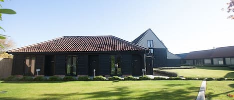 A two-story house with a sloped roof, a front porch, and a well-maintained lawn.