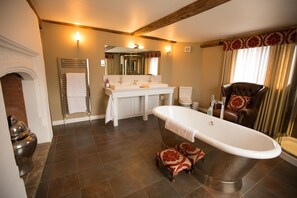 Relax in a classic bathroom with a bathtub, double sink vanity, and modern toilet.