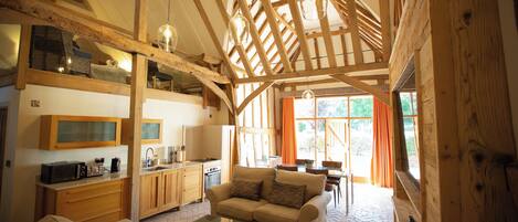 A spacious living area with a sofa, coffee table, and a kitchen in the background.