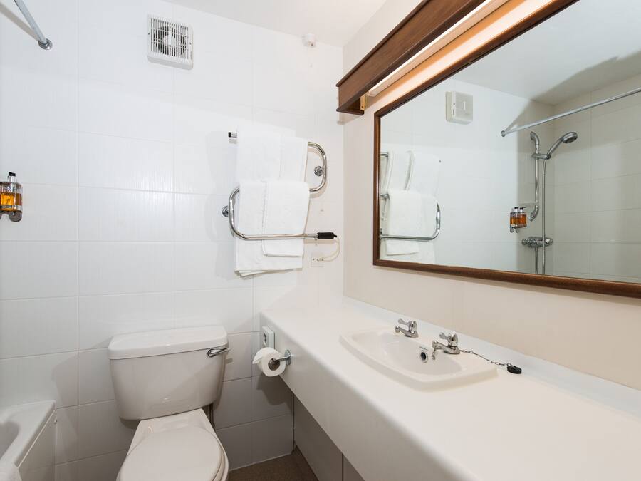 A bathroom with a toilet, sink, and shower.