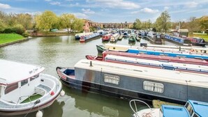 Un canal con varios barcos estrechos amarrados a lo largo del agua.