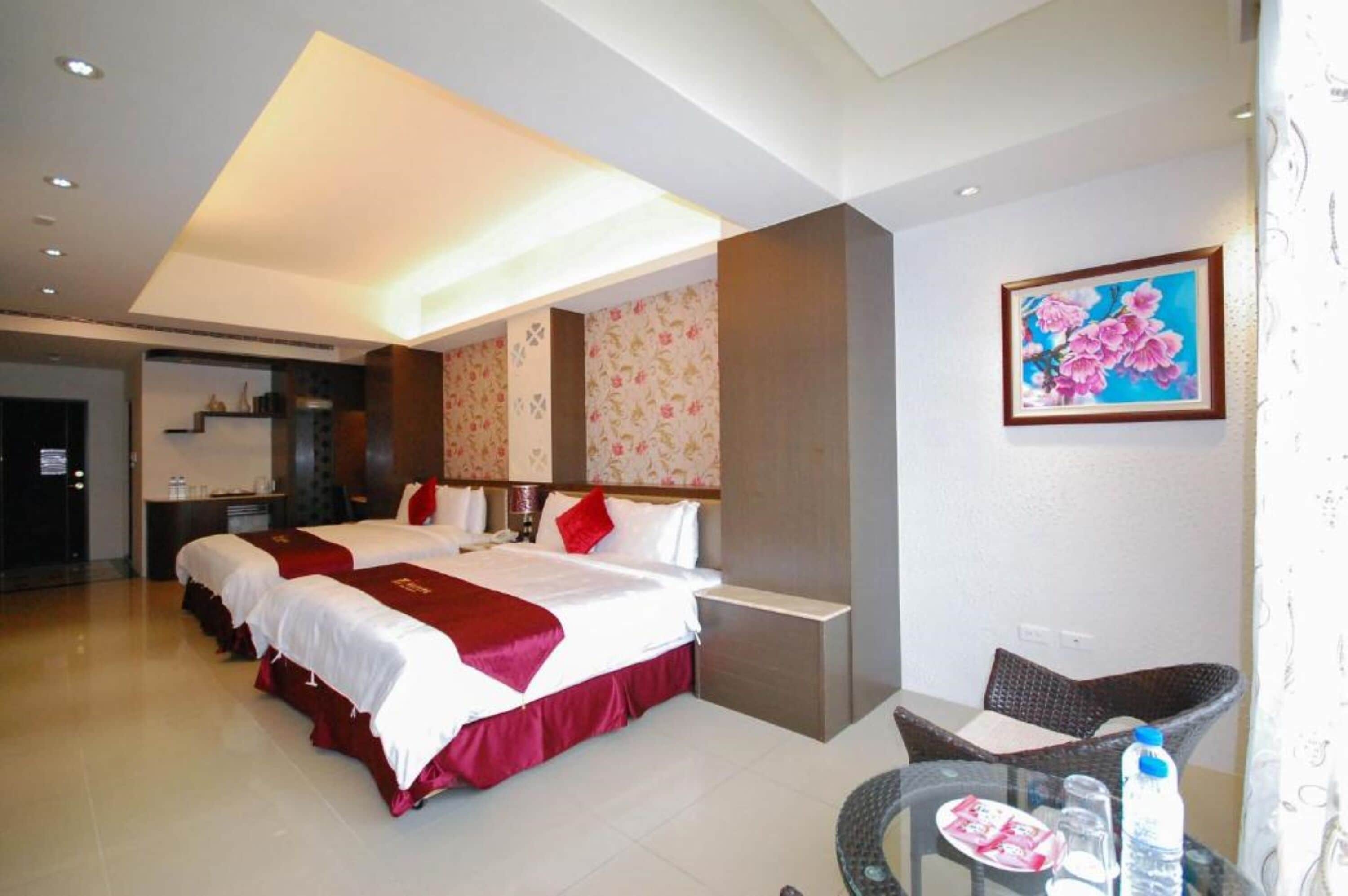 Une chambre d’hôtel avec deux lits, un coin repas et une salle de bain.