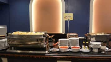 A buffet setup with various food items and condiments, including a sign for the egg station.