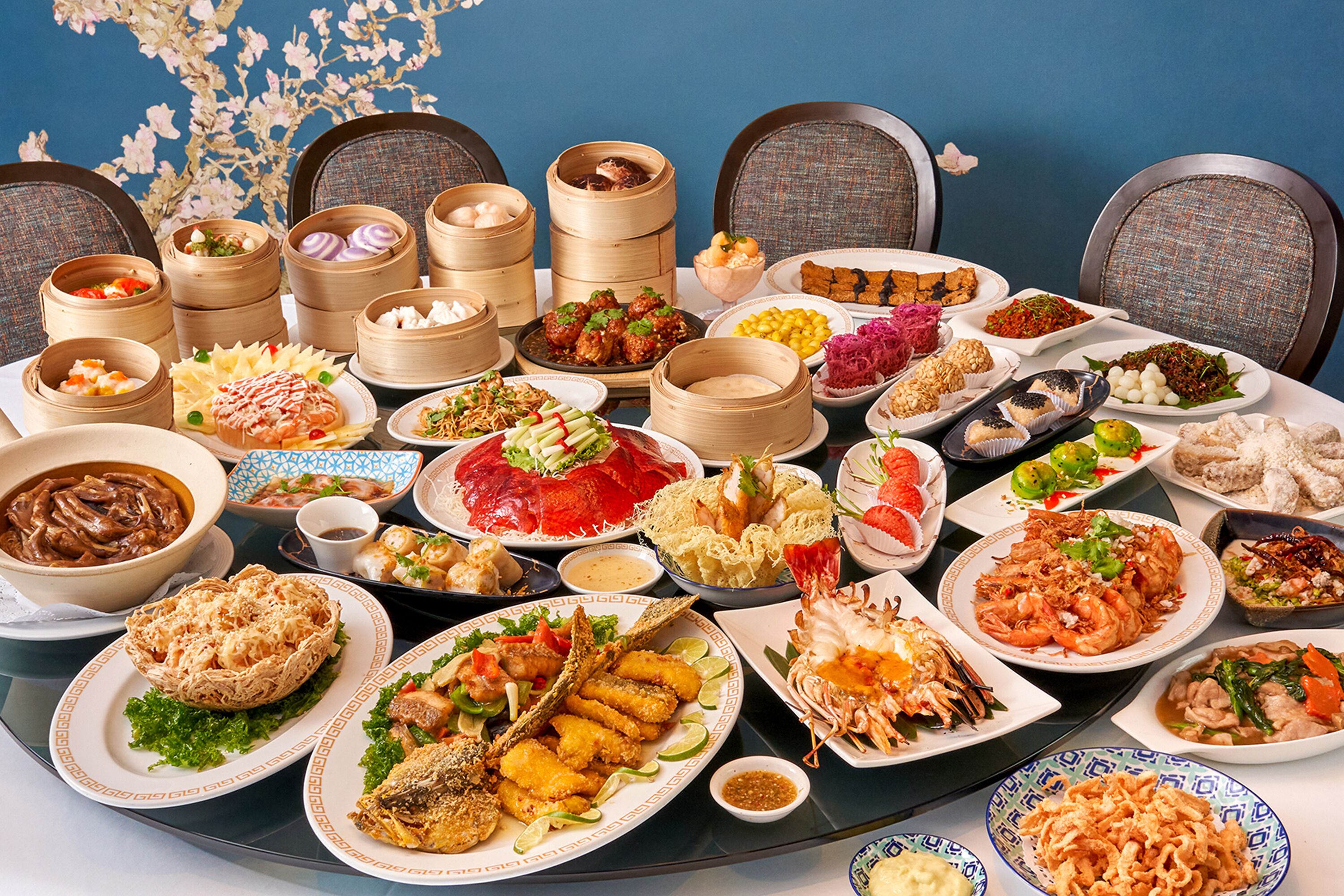 Une table dressée avec divers plats, notamment des fruits de mer, des raviolis et des légumes, préparés pour un repas.
