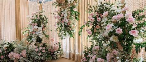 A floral arrangement with a backdrop of vertical panels and a decorative archway.