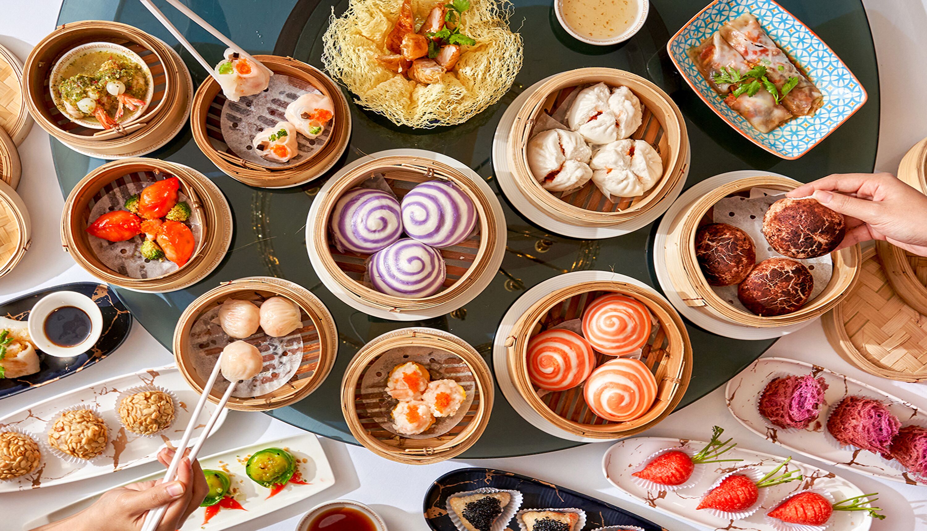 A variety of Asian dishes, including dumplings and sushi, served in bamboo steamers.