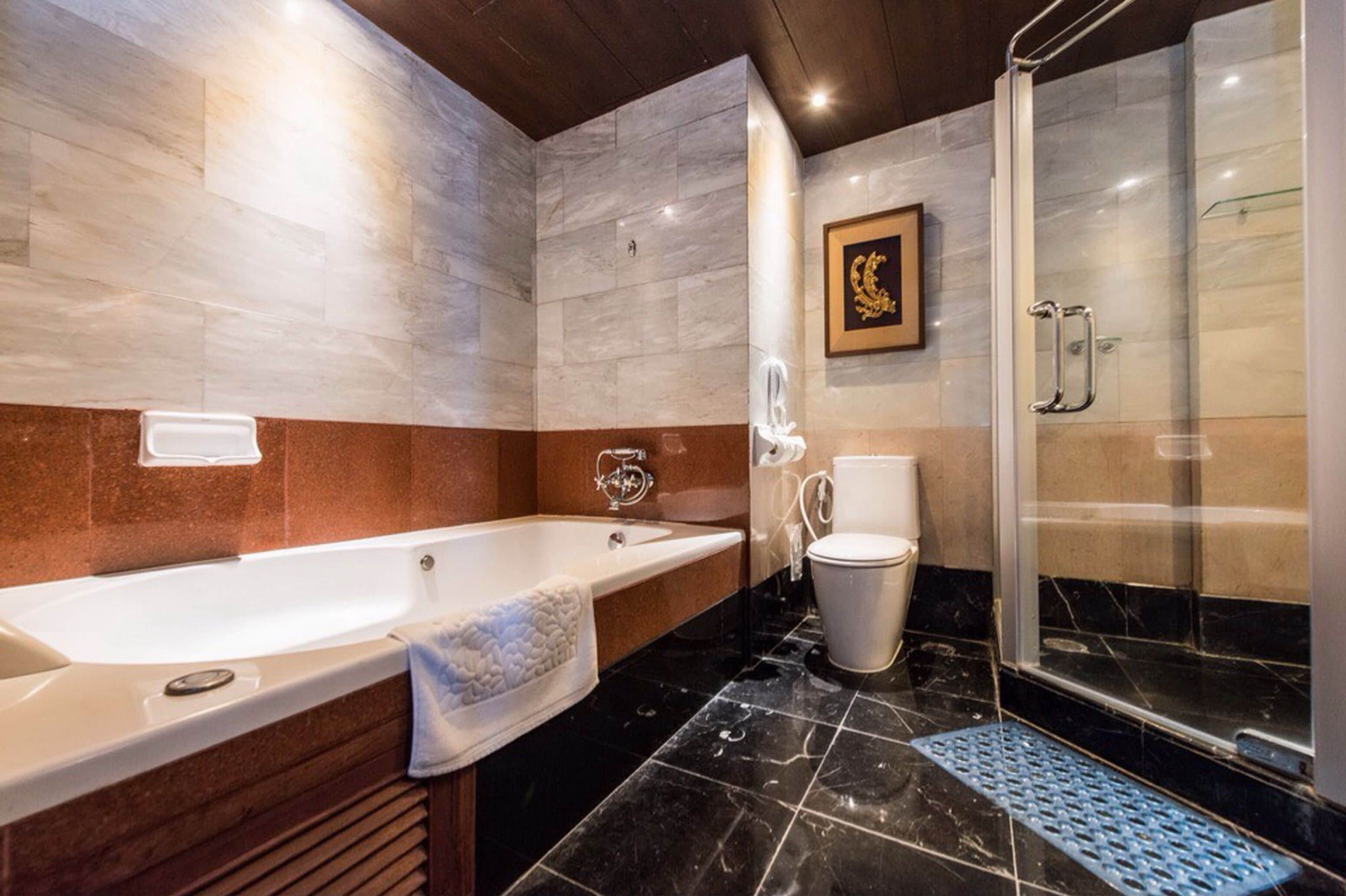 Et moderne badeværelse med badekar, bruser og toilet.