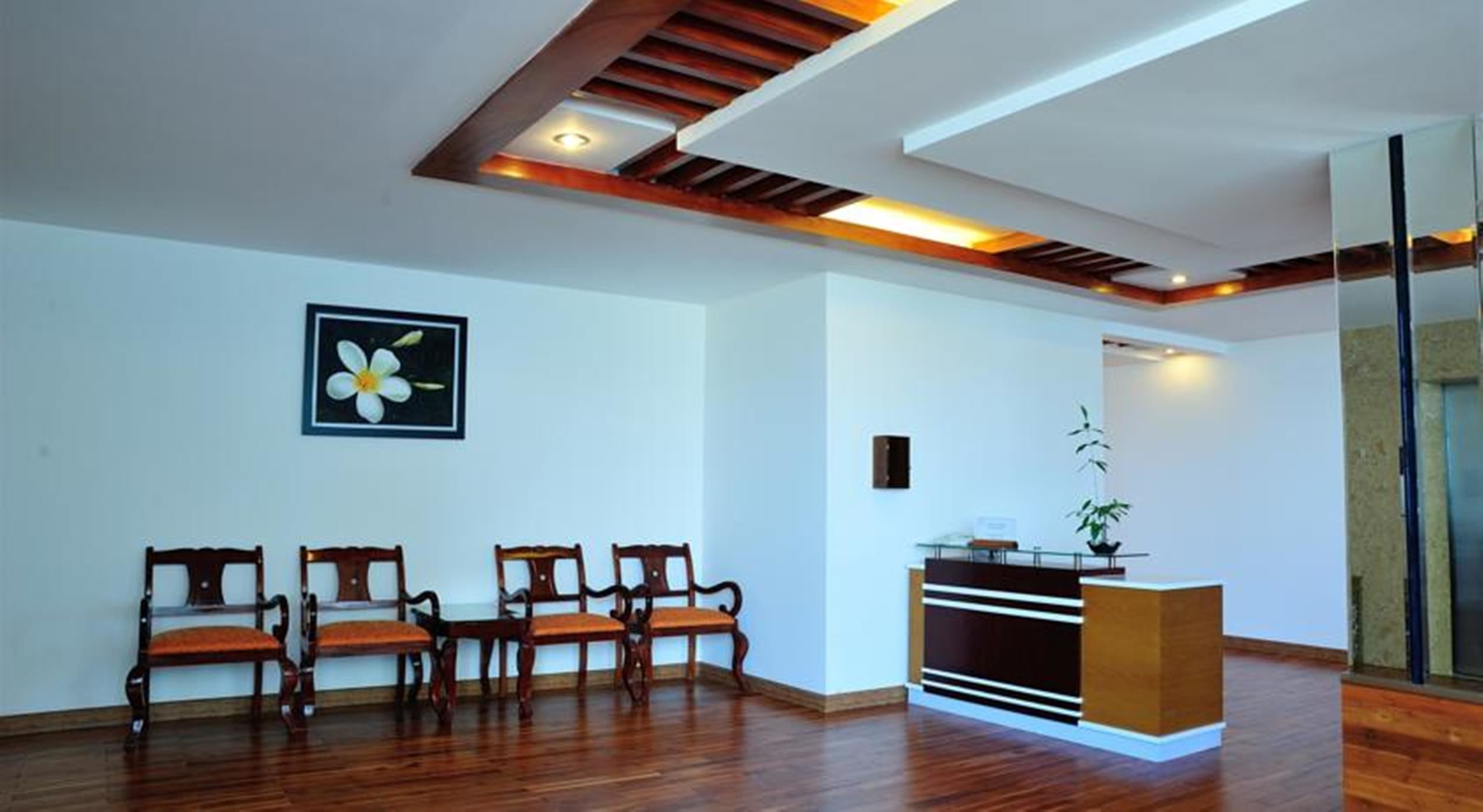 A spacious room with wooden flooring, a reception desk, and a framed picture on the wall.