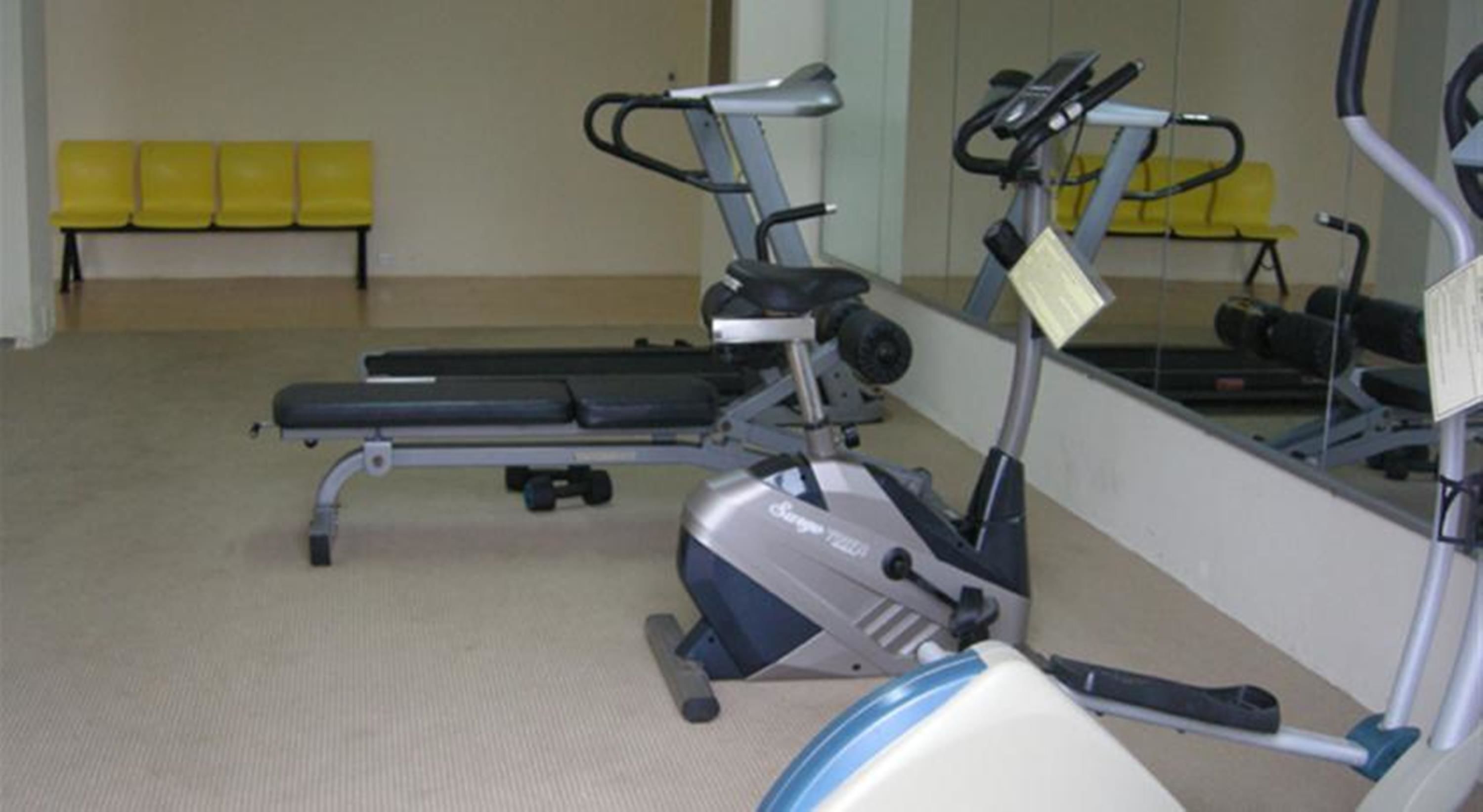 A gym with exercise equipment including a treadmill and a stationary bike.