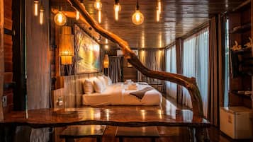 A room with a bed, wooden furniture, and hanging lights.