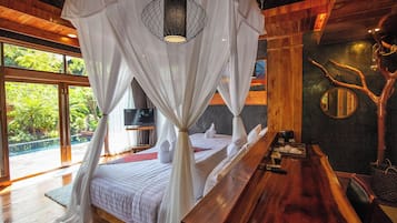 A room with a bed under a canopy, a wooden bench, a television, and a large window with a view of greenery.