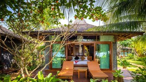 A tropical-style villa with a thatched roof, a private garden, and a balcony with lounge chairs. - Andalay Beach Resort Koh Libong (Ko Libong)