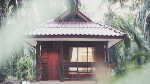 A small wooden cabin with a tiled roof, surrounded by dense tropical foliage. - Palm Garden Resort (Sikao)