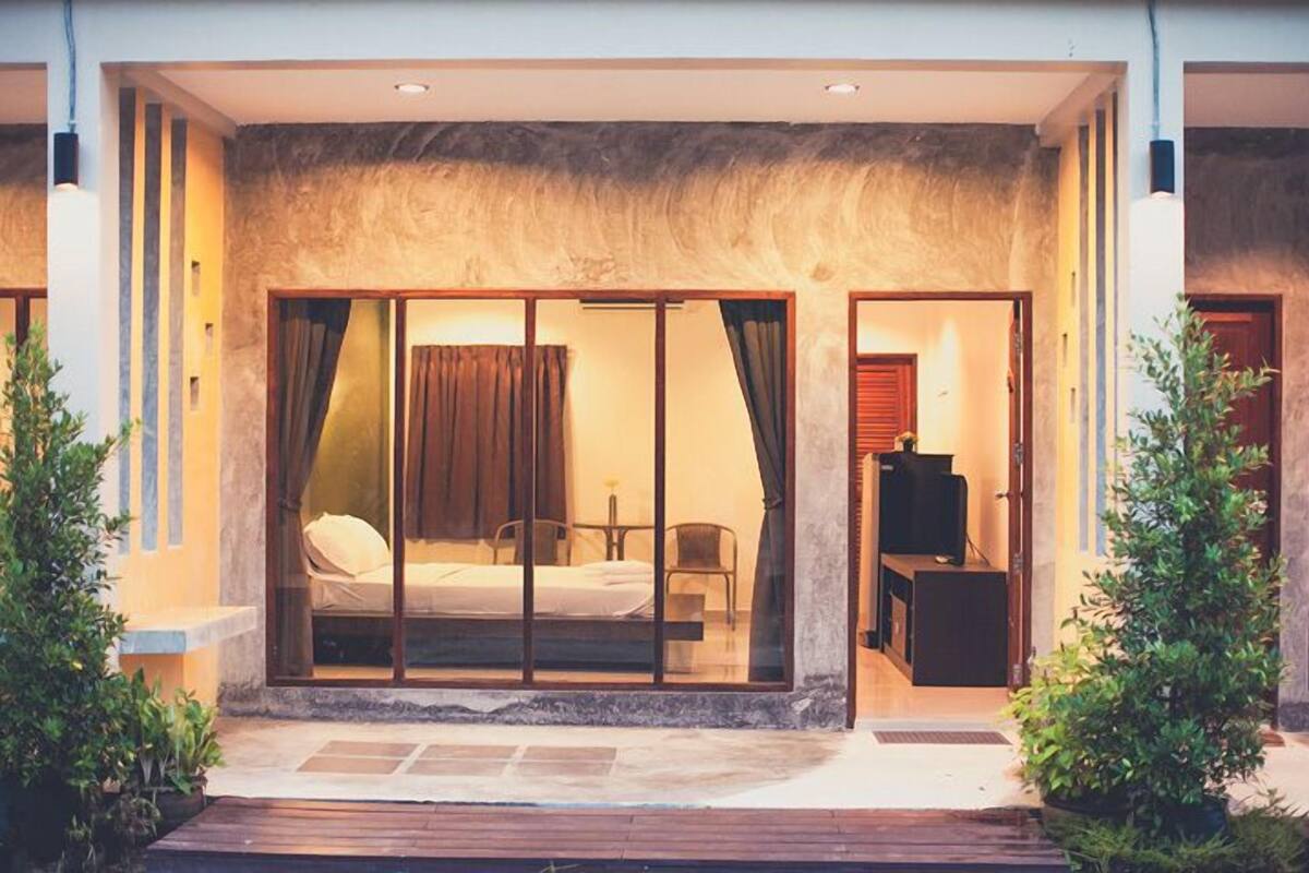A modern hotel room with a bed, a desk, and a television.