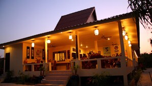 A beachfront building with multiple levels, a covered porch, and outdoor seating areas. - Buffalo Bay Vacation Club (Ranong)