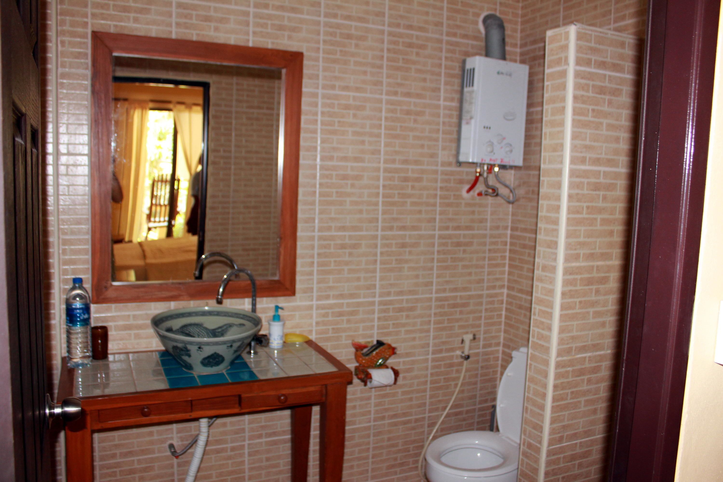 Une salle de bain avec un lavabo, un miroir et des toilettes.